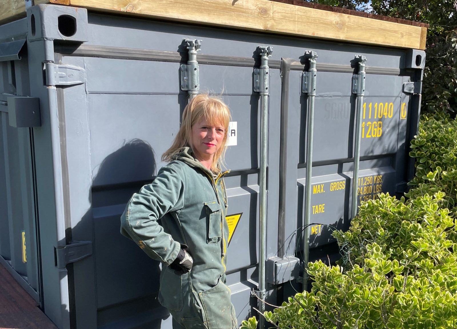 Nathalie en tenue de travail devant un container en cours de revalorisation